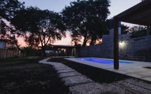 a backyard with a swimming pool at dusk at LA CASA DE AL LADO in Mercedes