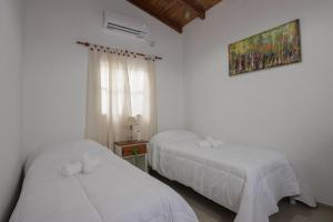 1 Schlafzimmer mit 2 Betten und einem Fenster in der Unterkunft LA CASA DE AL LADO in Mercedes