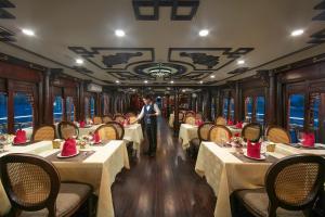 Un homme debout dans la voiture-salle à manger d'un train dans l'établissement Majestic Legend Cruise, à Hạ Long