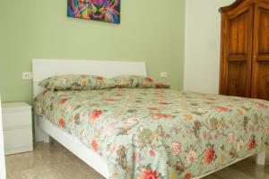 um quarto com uma cama com colcha floral em Casa di Nonna Rosy em Nápoles