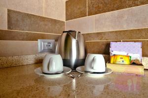 a metal tea pot on a table with two plates at Cavril Agriturismo in Sotto il Monte