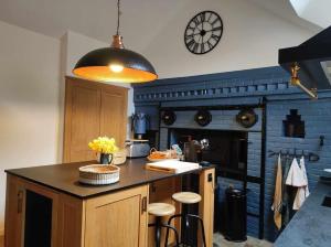a kitchen with a counter and a clock on the wall at La maison du Boulanger in Pontaubert