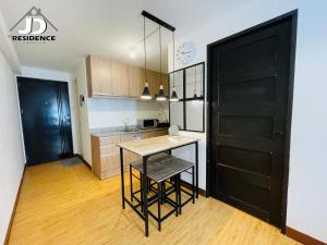 a kitchen with a table and a black door at JD Residence - 1 Bedroom Unit in Davao City