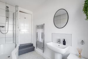a white bathroom with a sink and a mirror at Inspira Stays - Modern Stylish 2 Bedroom House - Free Parking - Wi-Fi - Monthly Discount in Leicester