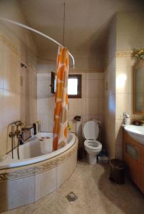 y baño con bañera, aseo y lavamanos. en VILLA NIKOLETTA en Eleftheroúpolis