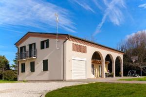 un grand bâtiment blanc avec un garage dans l'établissement Abano Terme - La Dolce Vita's Villa (comfort & serenity), à Abano Terme