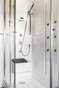 La salle de bains blanche est pourvue d'une douche et d'un lavabo. dans l'établissement Abano Terme - La Dolce Vita's Villa (comfort & serenity), à Abano Terme