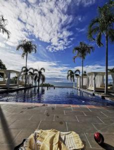 una piscina con palme e l'oceano di El Palmar Beach Residences 901 Beach Front View a Las Palmeras