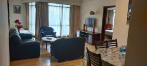 uma sala de estar com uma poltrona e uma mesa em Best Facilities Services Suites At Times Square kl em Kuala Lumpur