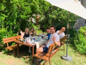a group of people sitting at a table under an umbrella at Poreč Villa Mihaela in Poreč