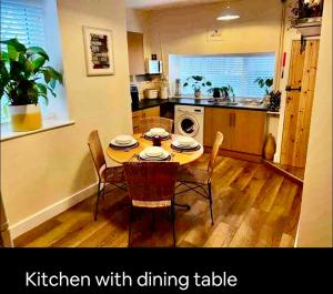 a kitchen with a table and chairs and a kitchen with dining table at Kookaburra lodge in Brecon