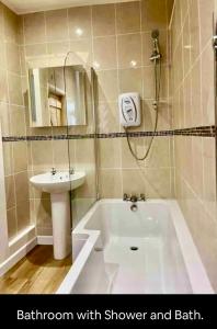 uma casa de banho com um chuveiro, um lavatório e uma banheira em Kookaburra lodge em Brecon