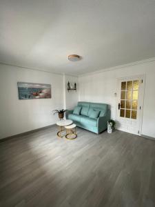 a living room with a blue couch and a table at EL MARINERITO Alcocebre in Alcossebre