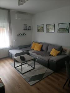 uma sala de estar com um sofá e uma mesa em Apartman HD em Dakovo