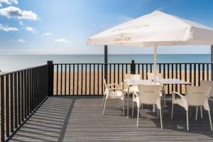 un patio con tavoli e sedie e ombrellone in spiaggia di Stylish townhouse + parking, seconds from the sea a Brighton & Hove