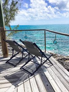 dwa krzesła siedzące na tarasie przy oceanie w obiekcie Ocean Shire home w mieście Alice Town