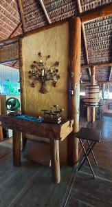 een tafel in een kamer met een klok aan de muur bij Pousada Bangalô de Barro in Paraty
