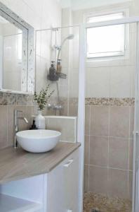 uma casa de banho com um lavatório branco e um chuveiro em Apt Parisian Charm with Amazing View Near Metro em Asnières-sur-Seine
