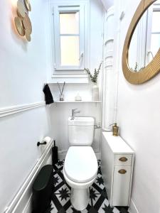 uma casa de banho com um WC branco e um espelho. em Apt Parisian Charm with Amazing View Near Metro em Asnières-sur-Seine