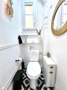 a bathroom with a white toilet and a mirror at Apt Parisian Charm with Amazing View Near Metro in Asnières-sur-Seine
