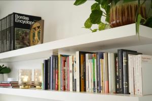 a shelf full of books in a room at Apt Parisian Charm with Amazing View Near Metro in Asnières-sur-Seine