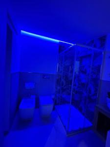 ein Bad mit WC und blauem Licht in der Unterkunft LA MEDUSA in Syrakus