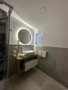 ein Bad mit einem Waschbecken und einem Spiegel in der Unterkunft LA MEDUSA in Syrakus