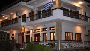 un gran edificio blanco con una bandera americana en él en Ευήλιον Σουίτες, en Elati