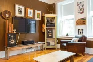 uma sala de estar com um sofá e uma televisão em iKlektik House // BlueJay em Chicago