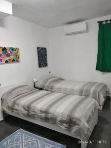 two beds in a room with white walls at A casa di Pietro 
