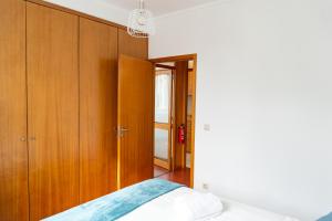 a bedroom with a bed and wooden cabinets at Lovely Cedofeita Apartment by Unique Hosts in Porto