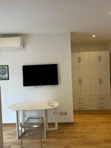 a room with a table and a tv on a wall at Aurelia Antica ELLE Apartment in Rome