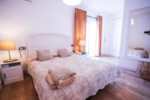 a bedroom with a large bed and two windows at HABANERAS in Torrevieja