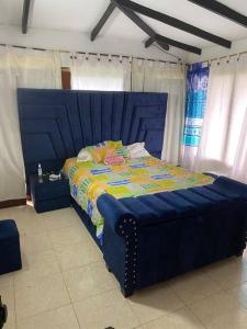 Una cama azul con cabecero azul en un dormitorio en Finca de Descanso Villa Edelmira, en Yumbo