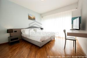 a bedroom with a bed and a desk and a chair at Suites Marilia Apartments - Suite Livorno Holiday Home Group in Livorno