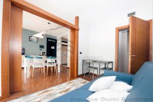 a living room and dining room with a blue couch at Suites Marilia Apartments - Suite Livorno Holiday Home Group in Livorno