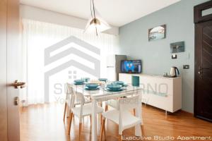 a kitchen and dining room with a table and chairs at Suites Marilia Apartments - Suite Livorno Holiday Home Group in Livorno