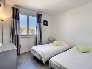 um quarto com 2 camas e uma janela em Berlioz Garden - Jardin,Free Parking,AC,Wifi em Antibes