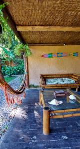 een patio met 2 bedden en een hangmat bij Pousada Bangalô de Barro in Paraty