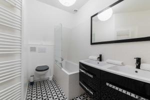 uma casa de banho branca com um lavatório e um WC em 4 pièces 90m2 centre Kremlin-Bicêtre - 6p em Le Kremlin-Bicêtre