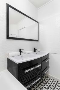 uma casa de banho com um lavatório e um espelho em 4 pièces 90m2 centre Kremlin-Bicêtre - 6p em Le Kremlin-Bicêtre