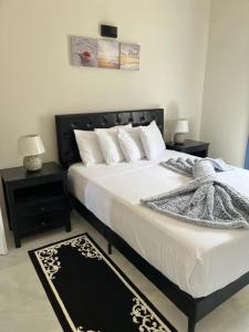 sypialnia z dużym łóżkiem z białą pościelą i poduszkami w obiekcie Paris' -Oasis w mieście Discovery Bay