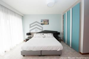 a bedroom with a white bed and blue walls at Suites Marilia Apartments - Suite Livorno Holiday Home Group in Livorno