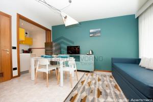a living room with a table and a blue wall at Suites Marilia Apartments - Suite Livorno Holiday Home Group in Livorno