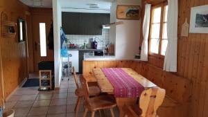 a kitchen with a wooden table and chairs in it at Chalet Sonnenblick in Fiesch