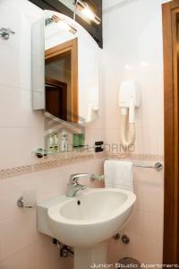 a bathroom with a sink and a mirror at Suites Marilia Apartments - Suite Livorno Holiday Home Group in Livorno