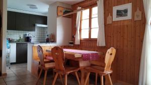 a kitchen with a wooden table and chairs at Chalet Sonnenblick in Fiesch