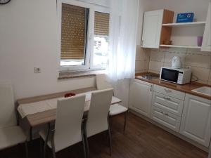 kuchnia ze stołem, krzesłami i kuchenką mikrofalową w obiekcie Apartman Vanja w mieście Rijeka