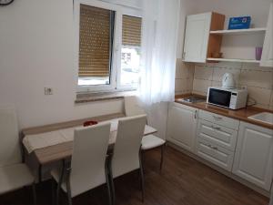 Una cocina con mesa y sillas y un microondas. en Apartman Vanja, en Rijeka 8 fotos más