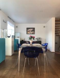 a dining room with a table and blue chairs at Moderne Wohnung 15min International Airport Messe DÜS in Willich